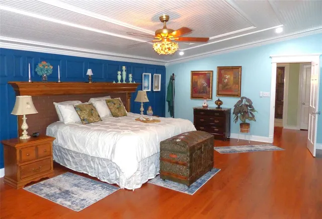 a spacious bedroom with a bed and a chandelier