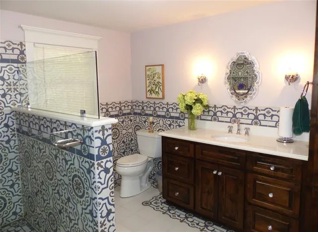 a bathroom with a sink vanity granite and toilet