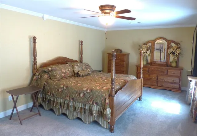 a bedroom with a bed a chandelier and dresser