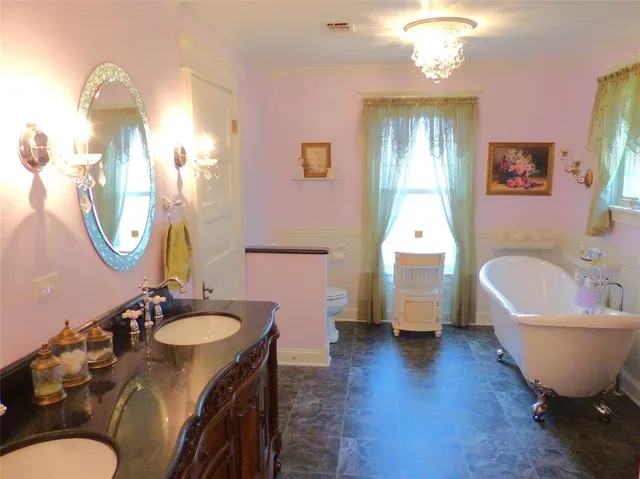 a spacious bathroom with a bathtub sink and mirror