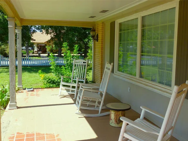 a view of a porch with chairs and backyard