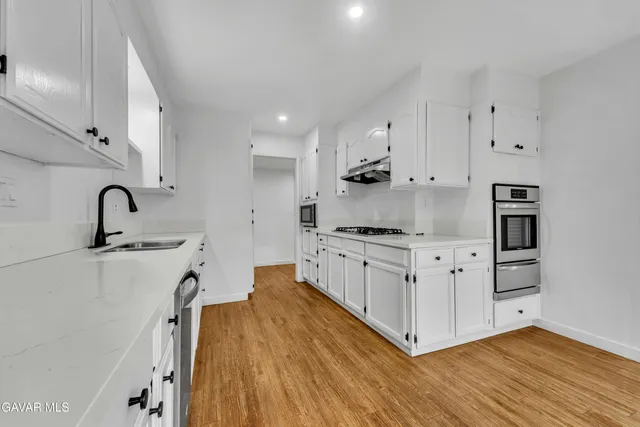 a kitchen with white cabinets and appliances