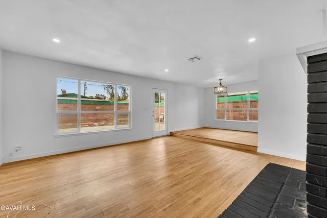 a view of an empty room with a fireplace and a window