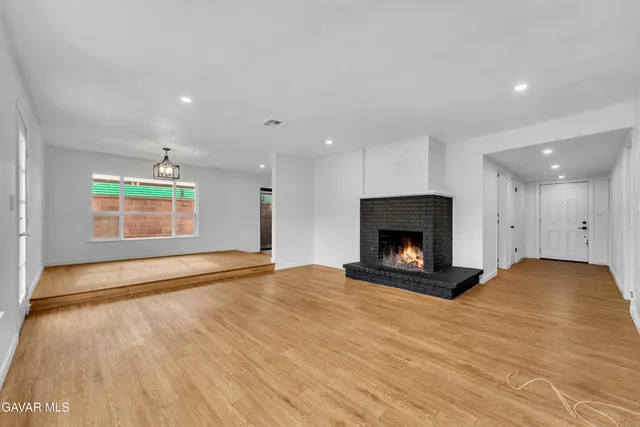 an empty room with kitchen fireplace and windows