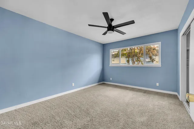a view of a big room with a ceiling fan and a window