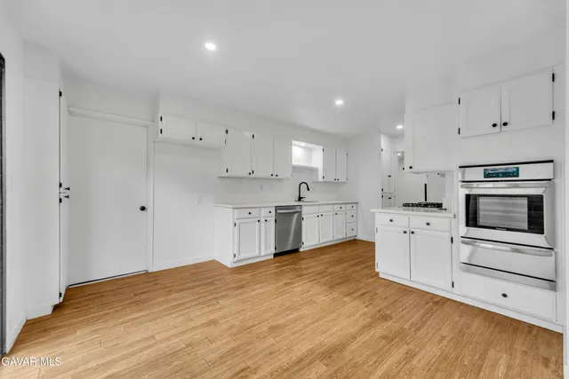 a kitchen with white cabinets and appliances