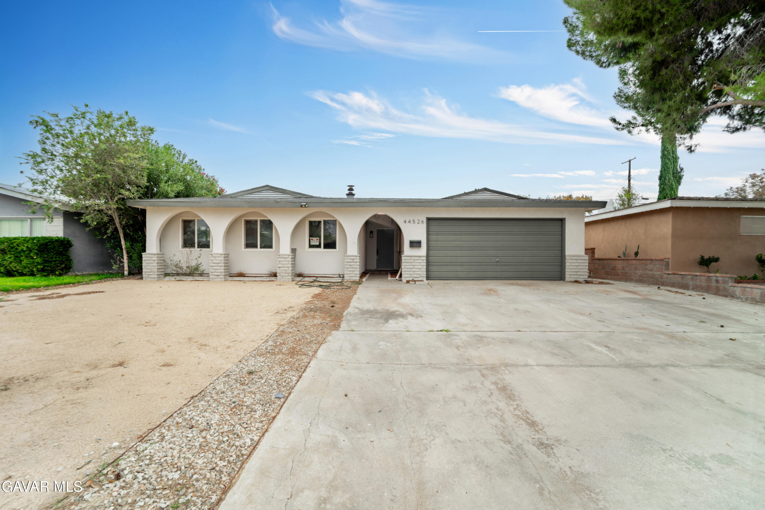44526 Stanridge Avenue Lancaster, CA 93535 - Photo 4 of 26 a front view of a house with a yard and garage