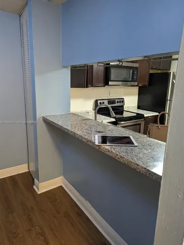 a kitchen with a sink a microwave a stove and refrigerator