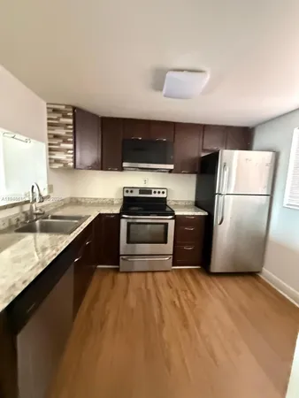 a kitchen with a refrigerator sink and stove