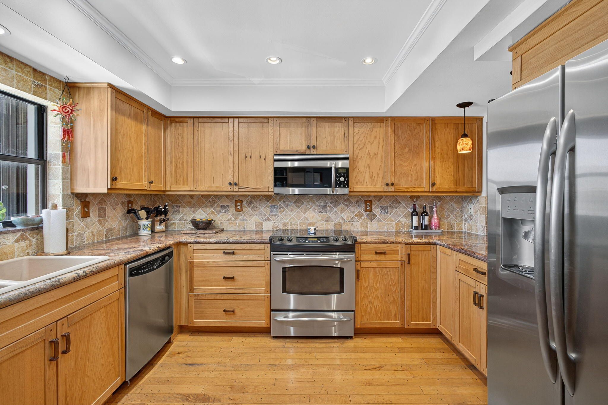 704 Clubhouse Circle Jupiter, FL 33477 - Photo 13 of 72 a kitchen with stainless steel appliances granite countertop a stove top oven a refrigerator and a sink