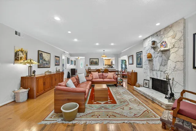 a bedroom with a bed a dresser next to a large window with the outer view