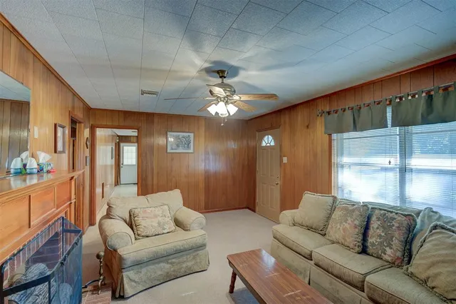 a living room with furniture a chandelier and a dining table