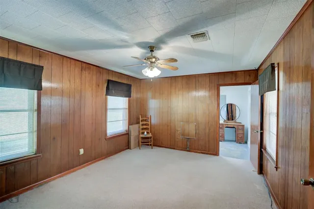 a furnished livingroom with a chandelier fan and windows