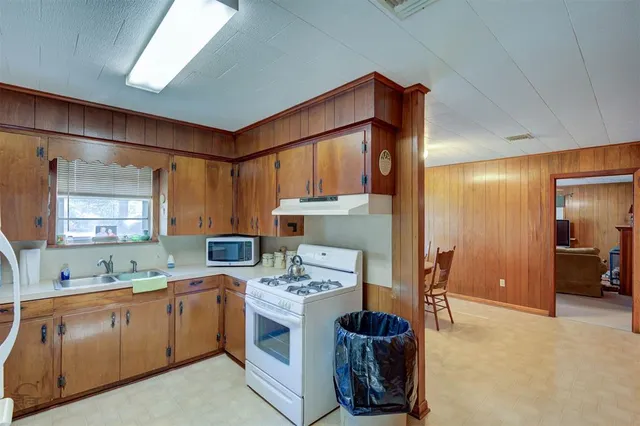 a kitchen that has a sink cabinets and a window