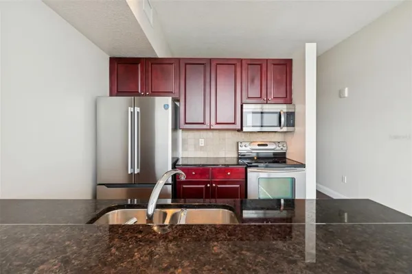 a kitchen with kitchen island a stove a refrigerator and wooden cabinets