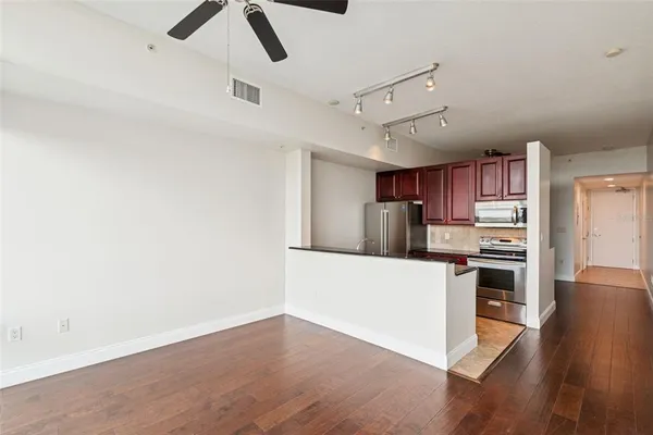 a kitchen with stainless steel appliances a stove top oven a sink a refrigerator and white walls