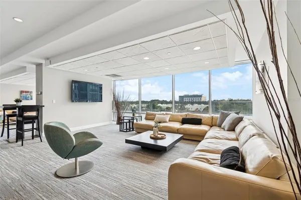 a kitchen with stainless steel appliances granite countertop a stove a refrigerator a kitchen island a sink a stove and white cabinets with wooden floor