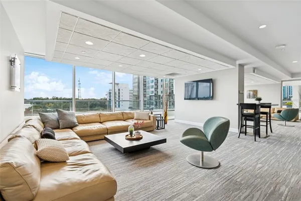 a large white kitchen with stainless steel appliances granite countertop a lot of counter space and a large window