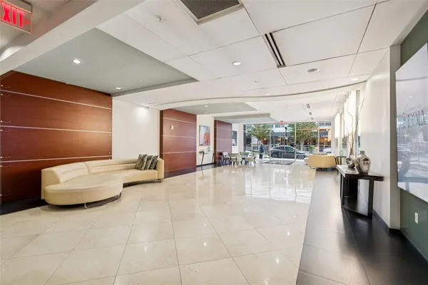 a dining hall with couches a fire pit and chairs