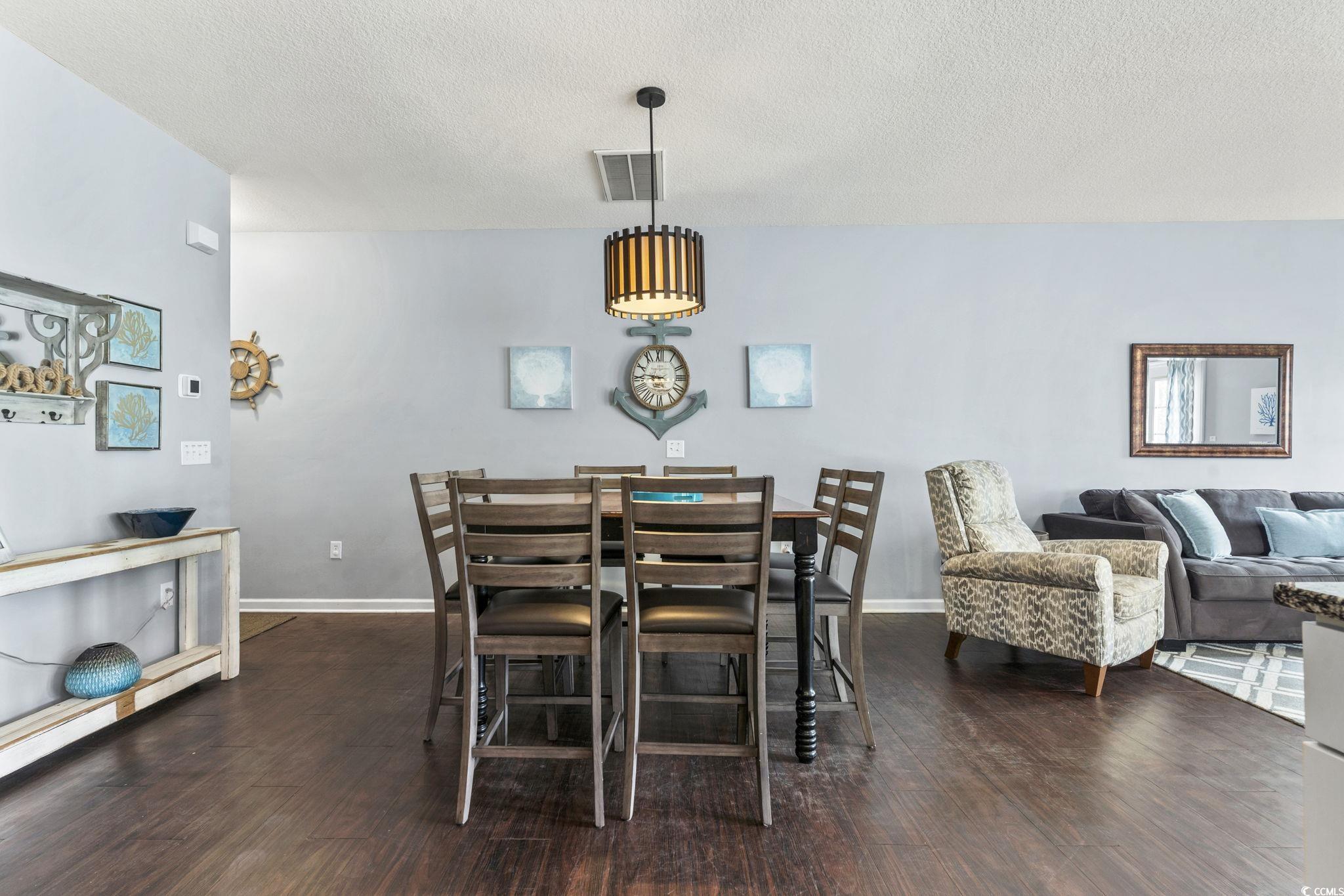 105 B Woodland Drive Murrells Inlet, SC 29576 - Photo 4 of 21 Dining room featuring a textured ceiling and dark wood-style floors