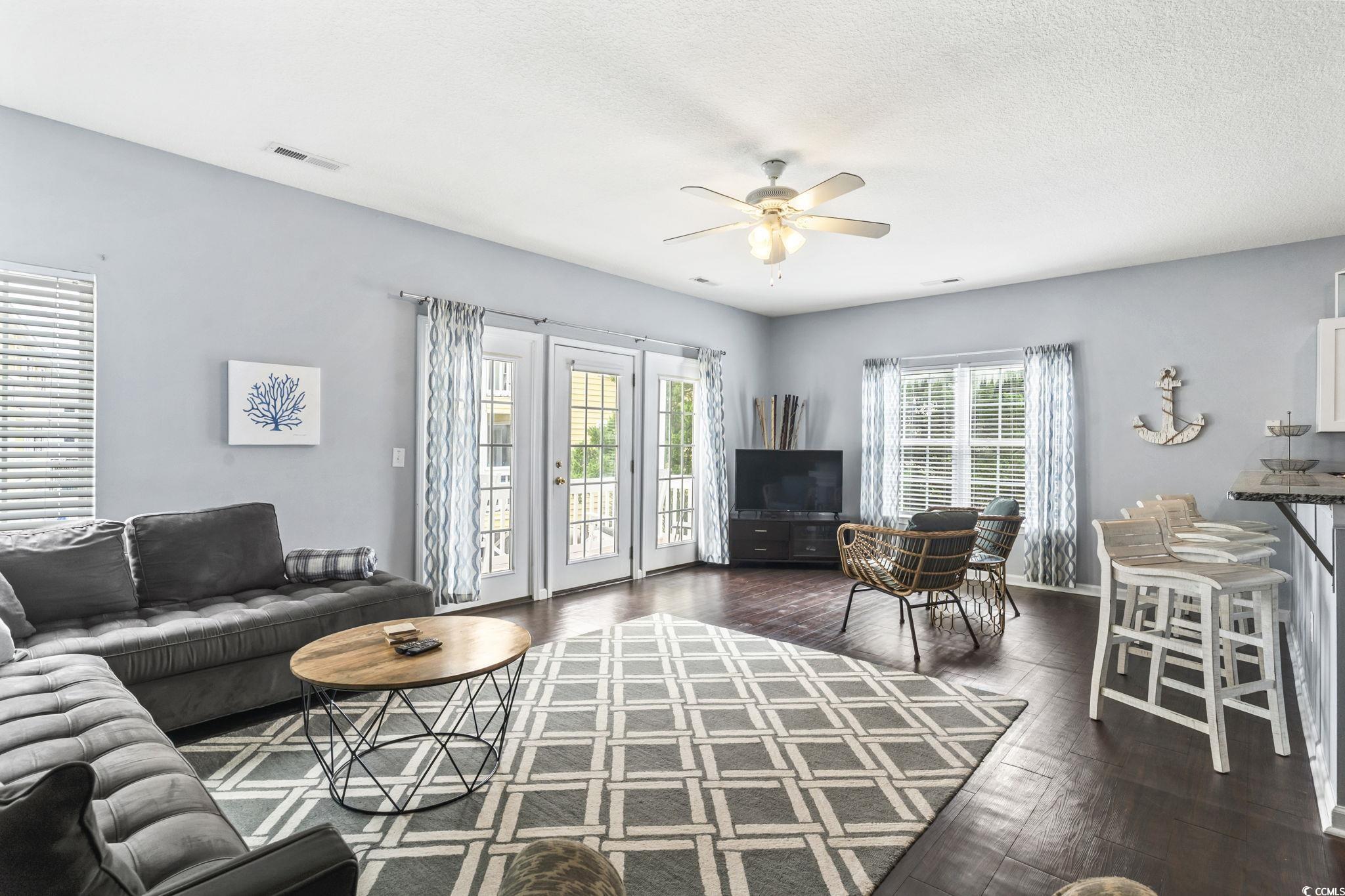 105 B Woodland Drive Murrells Inlet, SC 29576 - Photo 6 of 21 Living room featuring ceiling fan, dark wood-style flooring, and a textured ceiling