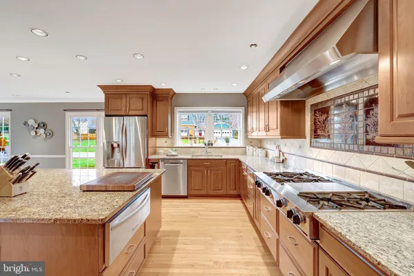 a kitchen with granite countertop a stove oven and white cabinets