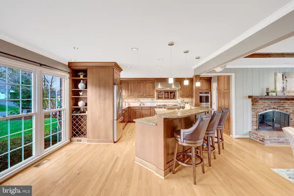 a kitchen with granite countertop kitchen island stainless steel appliances a sink stove and refrigerator