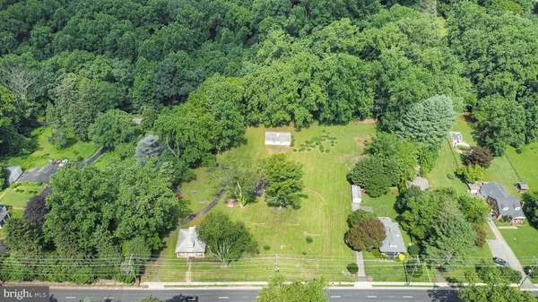 an aerial view of residential houses with outdoor space and trees all around