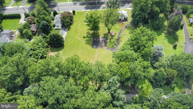 an aerial view of residential houses with outdoor space and trees all around