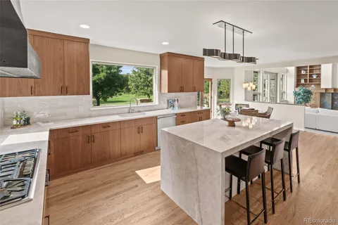 a large kitchen with cabinets wooden floor and stainless steel appliances