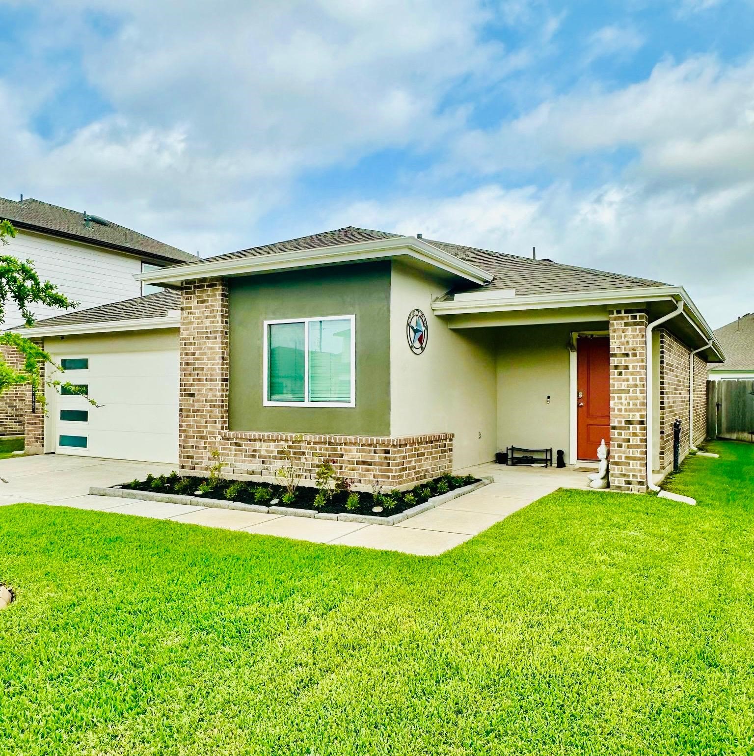 315 John House Lane Rosharon, TX 77583 - Photo 2 of 27 Charming single-story home with a modern exterior, featuring a well-maintained lawn in front. The property includes a two-car garage and a covered porch, perfect for a cozy and inviting entrance.