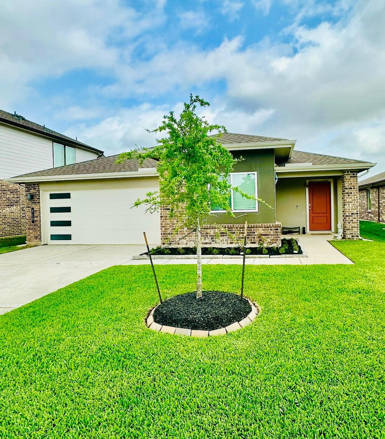 315 John House Lane Rosharon, TX 77583 - Photo 3 of 27 Charming single-story home with a modern exterior, featuring a well-maintained lawn in front. The property includes a two-car garage and a covered porch, perfect for a cozy and inviting entrance.