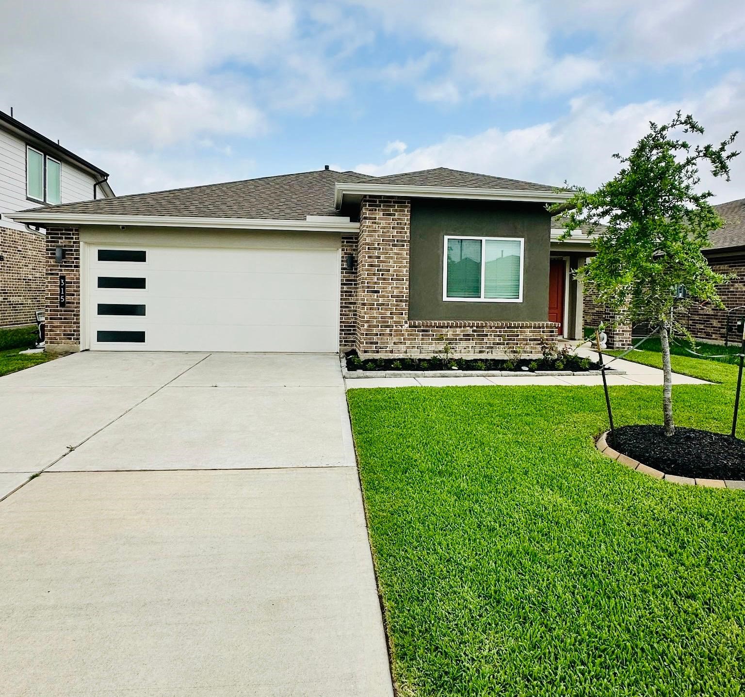 315 John House Lane Rosharon, TX 77583 - Photo 4 of 27 Charming single-story home with a modern exterior, featuring a well-maintained lawn in front. The property includes a two-car garage and a covered porch, perfect for a cozy and inviting entrance.