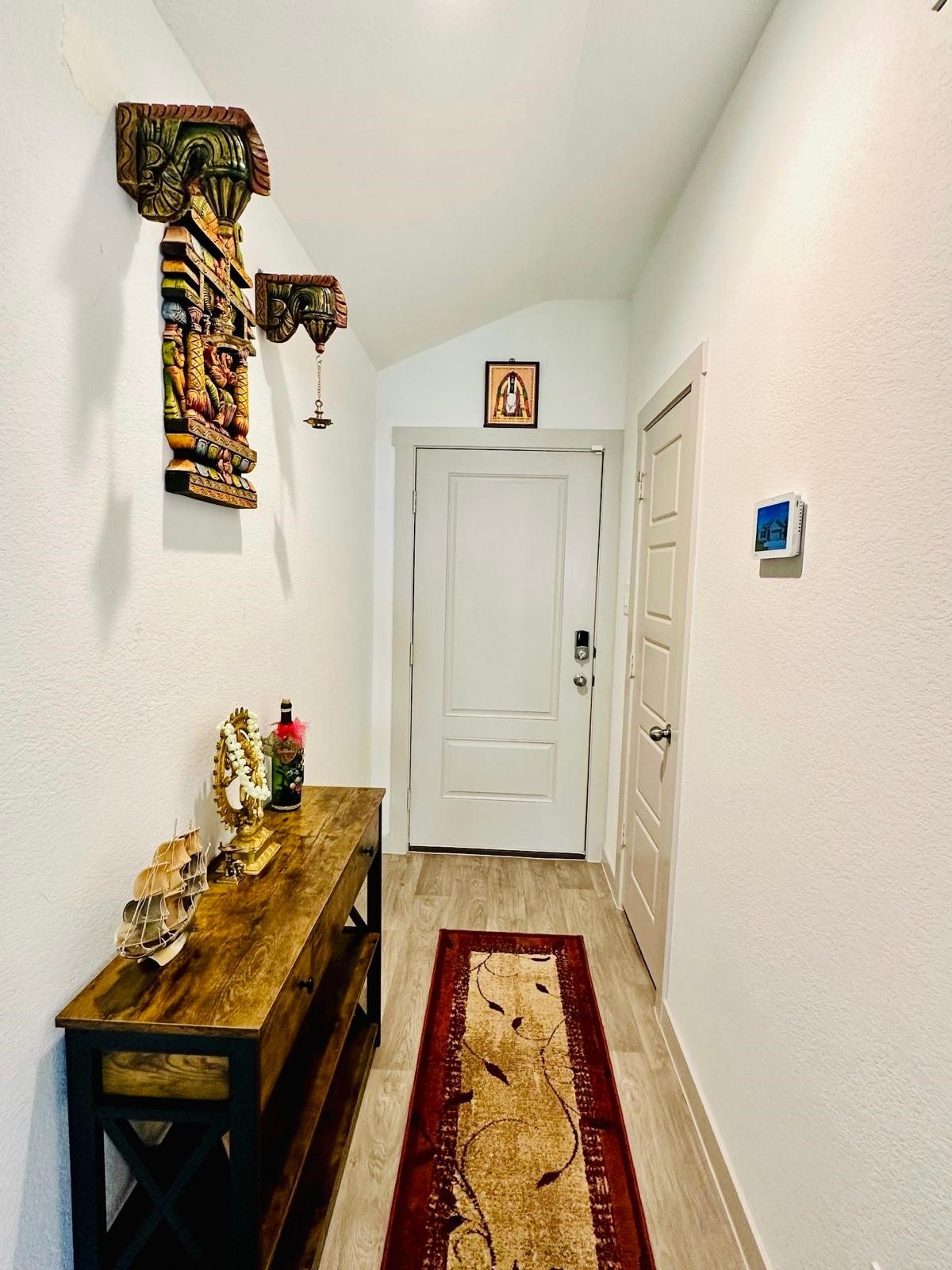 315 John House Lane Rosharon, TX 77583 - Photo 6 of 27 Inviting foyer with light walls and flooring. Features a decorative wooden console table and wall art, adding warmth and character.