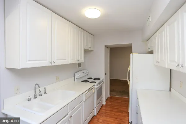 a kitchen with a sink a refrigerator and cabinets