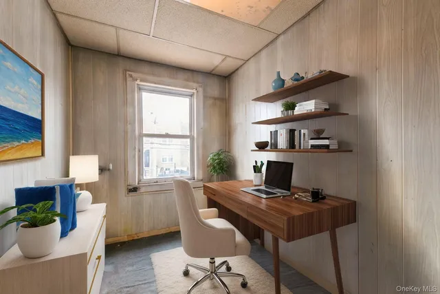 a view of a workspace with furniture and a window