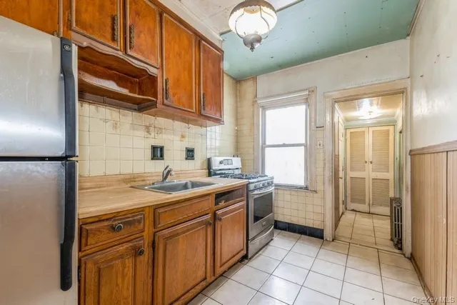 a kitchen with a sink stainless steel appliances a refrigerator and cabinets
