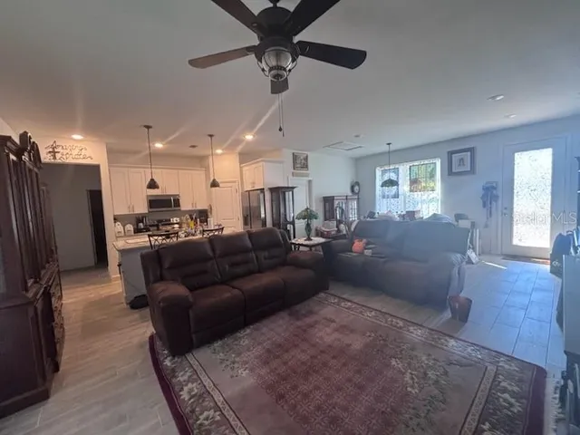 a living room with furniture and a view of kitchen