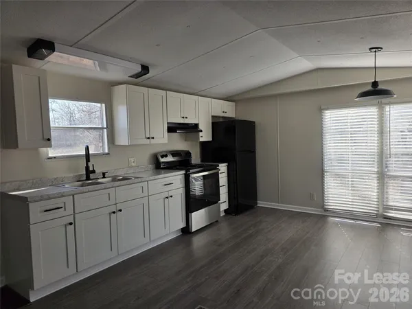 a kitchen with stainless steel appliances a sink cabinets and wooden floor