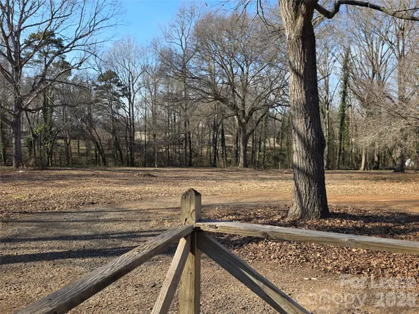 a view of a yard with wooden fence
