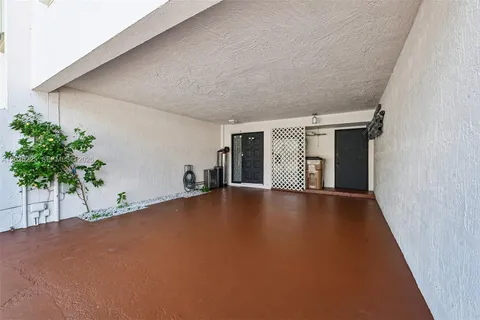 a view of an empty room with a window and potted plants
