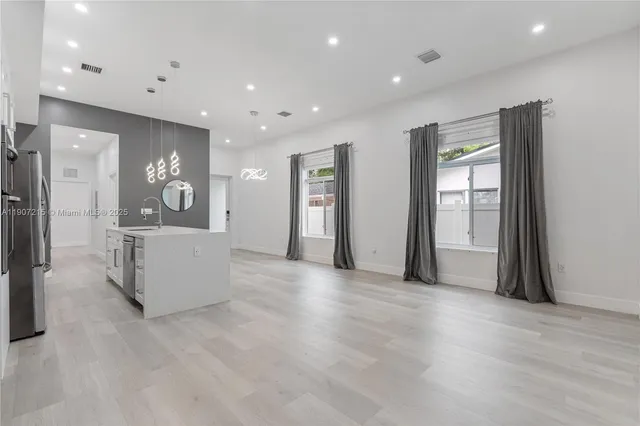 a view of a kitchen with refrigerator and windows