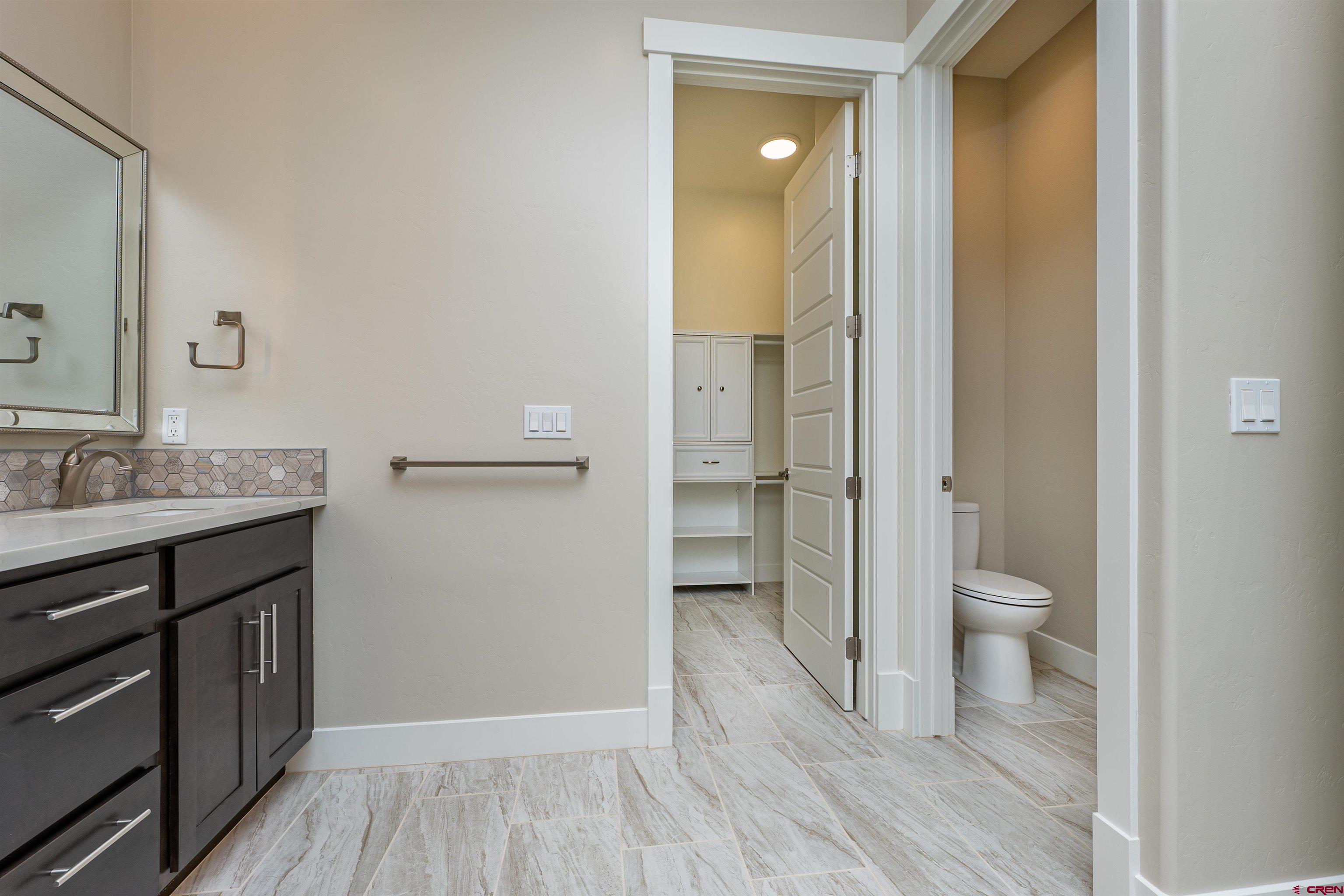 324 Hay Barn Road Durango, CO 81301 - Photo 22 of 35 a bathroom with a granite countertop toilet a sink and a mirror