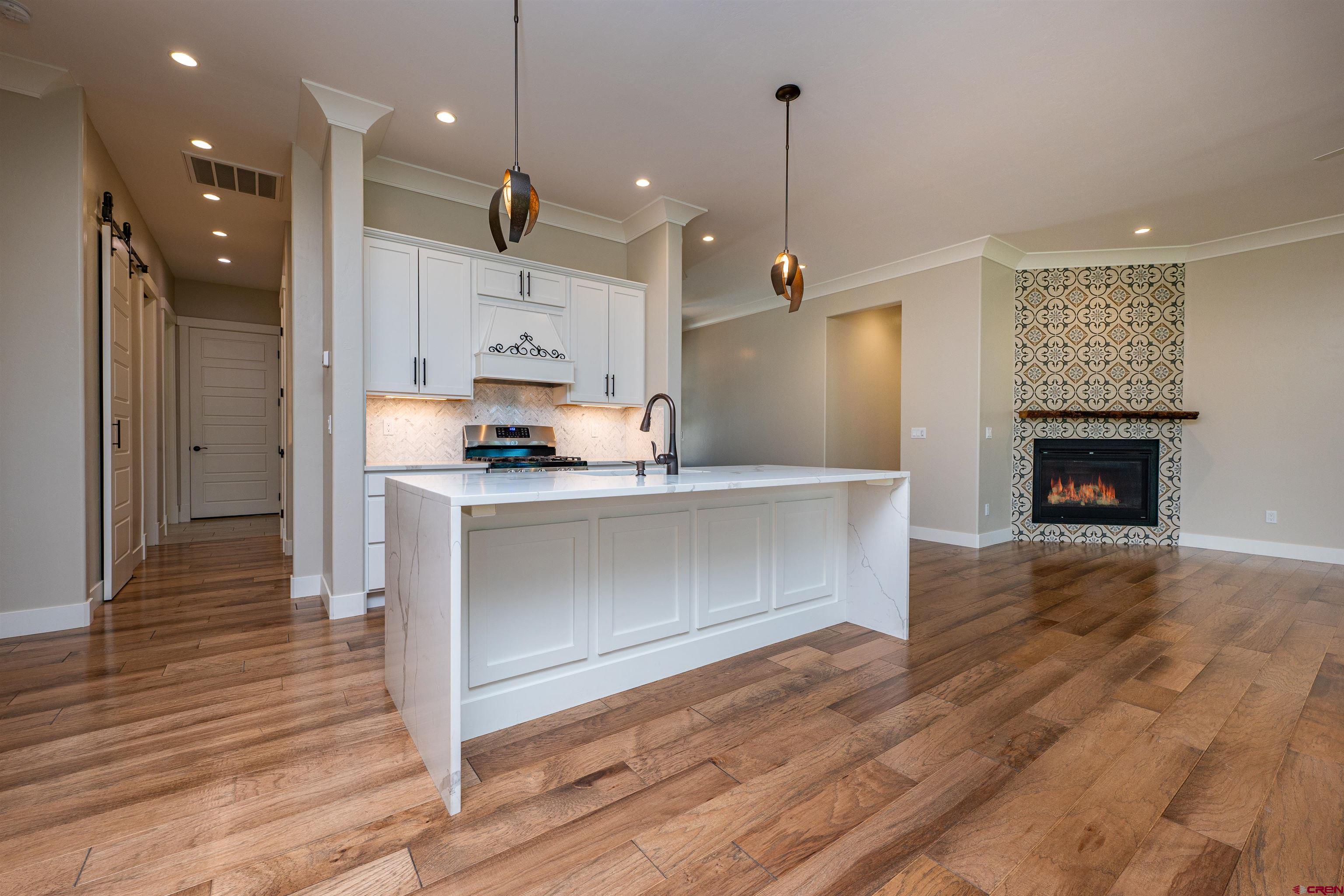 324 Hay Barn Road Durango, CO 81301 - Photo 5 of 35 a kitchen with kitchen island a sink stainless steel appliances and wooden floor