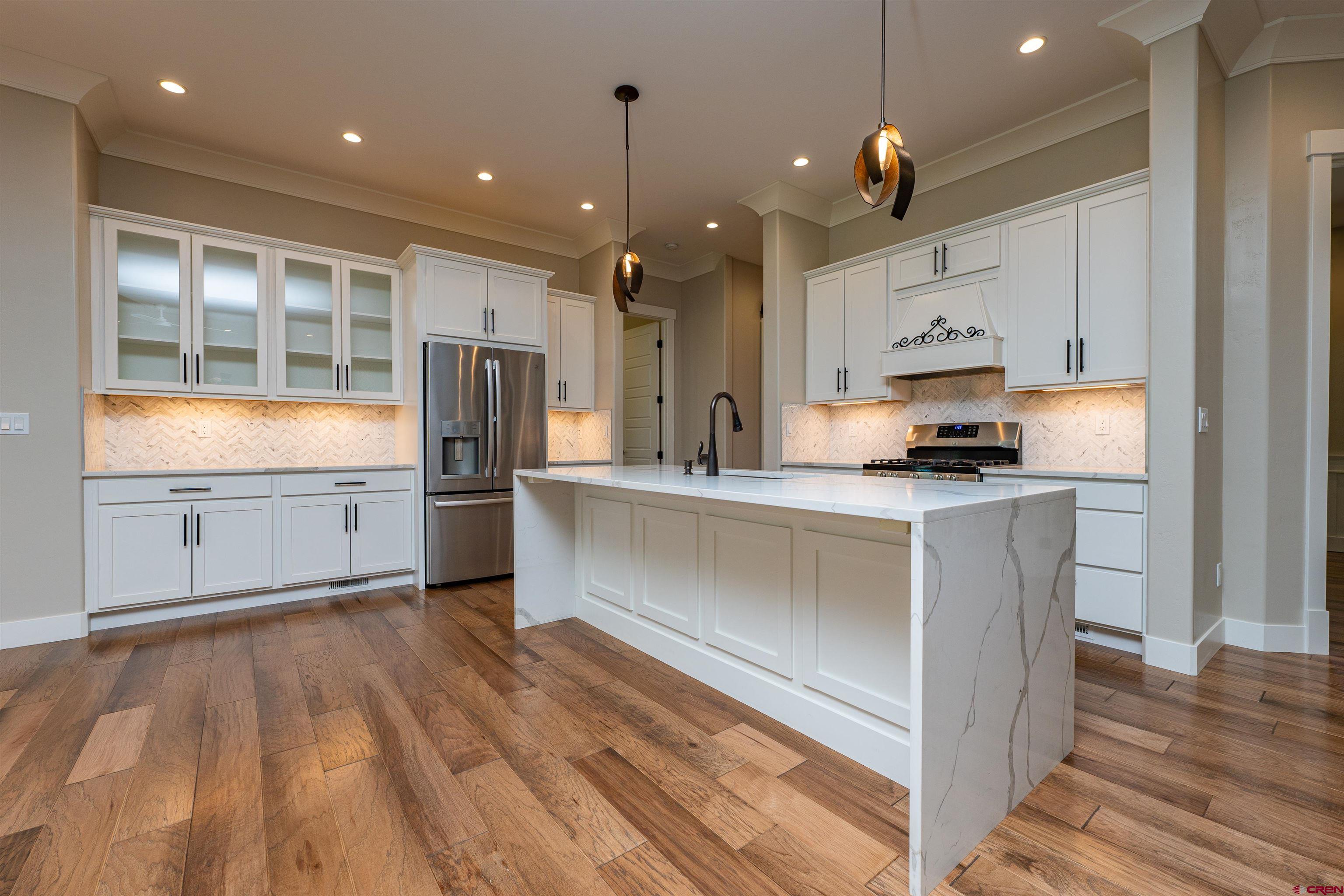 324 Hay Barn Road Durango, CO 81301 - Photo 6 of 35 a kitchen with kitchen island a counter top space a sink stainless steel appliances and cabinets