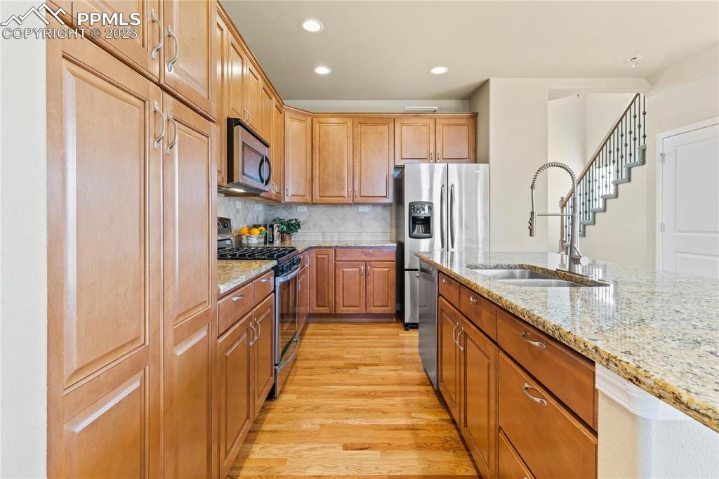 2423 Cinnabar Road Colorado Springs, CO 80921 - Photo 12 of 40 a large kitchen with stainless steel appliances granite countertop a sink and cabinets