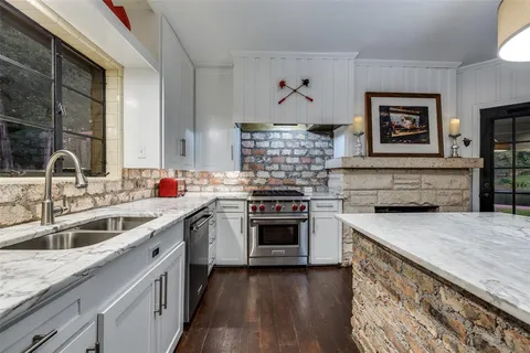 a kitchen with stainless steel appliances granite countertop a sink stove and cabinets