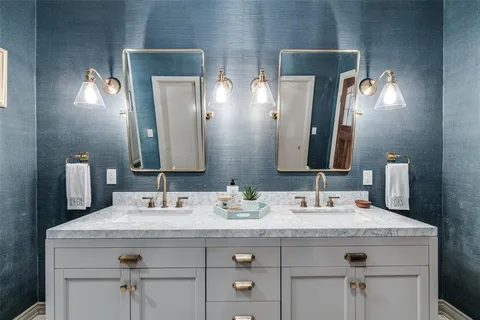 a bathroom with double vanity sinks and a mirror