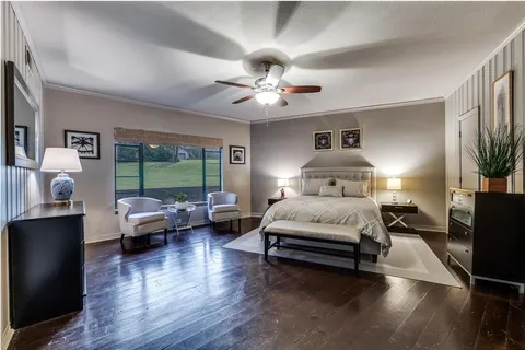 a spacious bedroom with a bed and a chandelier