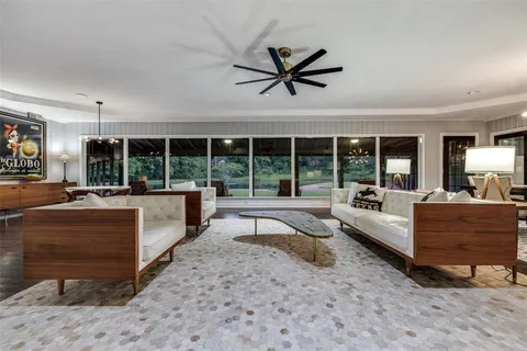 a living room with furniture floor to ceiling window and a table